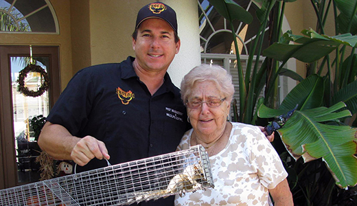 Scared Grandma Beside Holiday Pest Control Holding Squirrel Removed From Her House