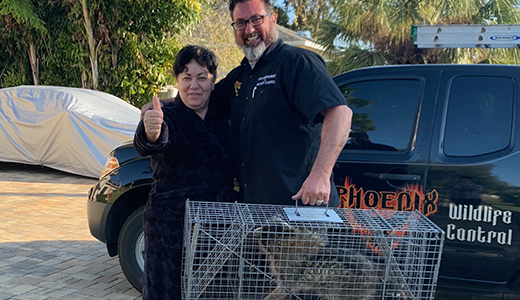 Happy Homeowner Beside Wildlife Removal Expert Who Caught Raccoon in Her Holiday FL House