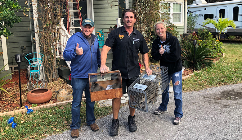 Couple Posing Beside Pest Control Expert Who Removed Raccoons From Their House in New Port Richey FL