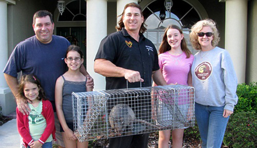 Lakewood Ranch Family Posing With Pest Control Expert Who Caught Armadillo From Their House